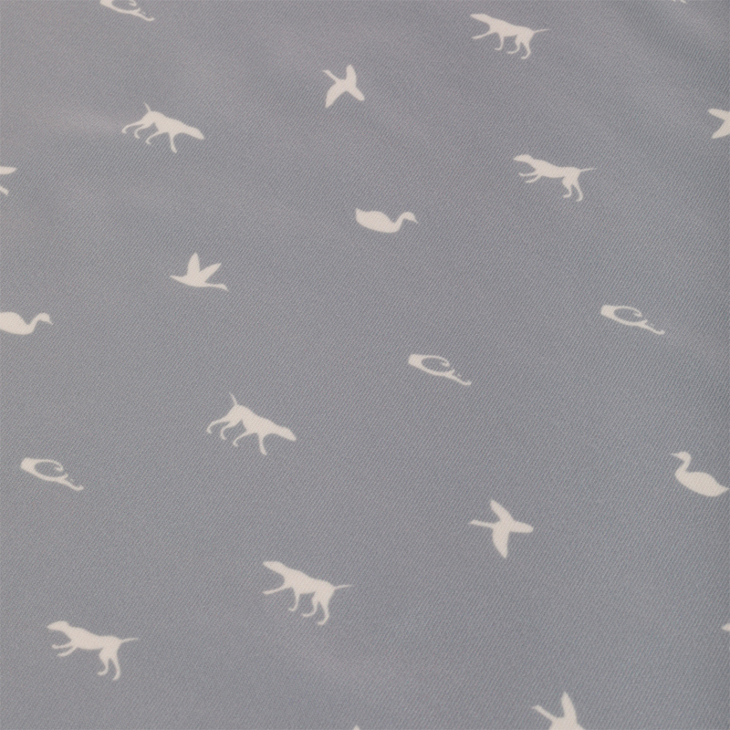 Performance Print Polo Shirt with grey fabric featuring white animals like dogs and birds. Equipped with a self-fabric collar, open cuffs, and split hem.