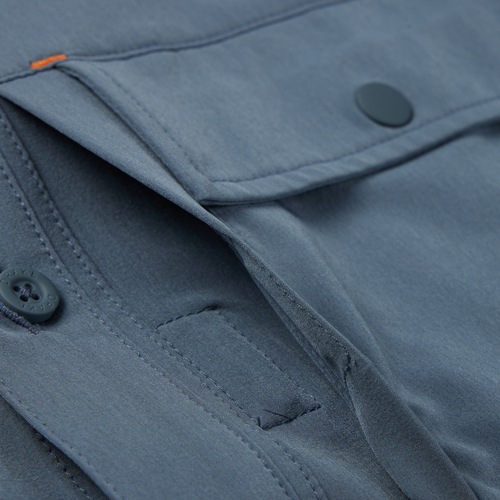 Lake Shore Performance Short Sleeve Shirt features close-up of button and pocket, showcasing technical details like Magnattach closure and vented cape back for outdoor versatility.