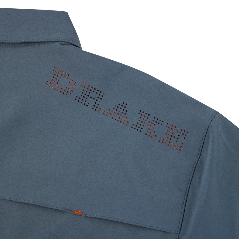 Close-up of the Lake Shore Performance Short Sleeve Shirt, showcasing vented cape back and button-through flap chest pockets, made from lightweight, moisture-wicking polyester/spandex fabric.