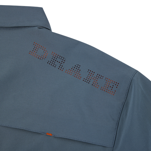 Close-up of the Lake Shore Performance Short Sleeve Shirt, showcasing vented cape back and button-through flap chest pockets, made from lightweight, moisture-wicking polyester/spandex fabric.