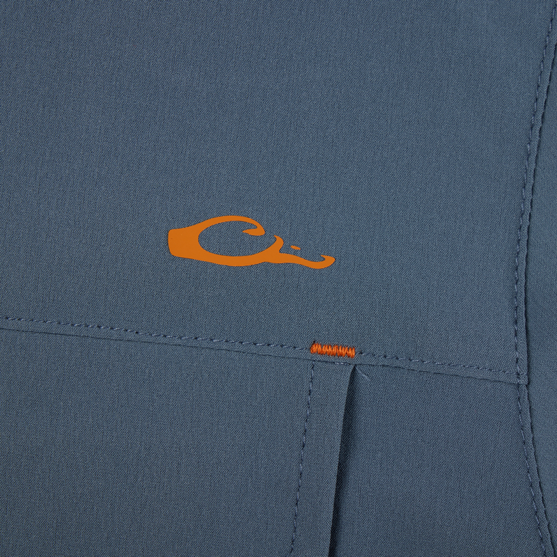 Lake Shore Performance Short Sleeve Shirt featuring an orange letter detail on blue fabric, highlighting its stretch, moisture-wicking capabilities, and vented cape back design.
