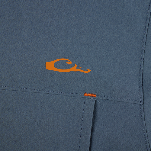 Lake Shore Performance Short Sleeve Shirt featuring an orange letter detail on blue fabric, highlighting its stretch, moisture-wicking capabilities, and vented cape back design.