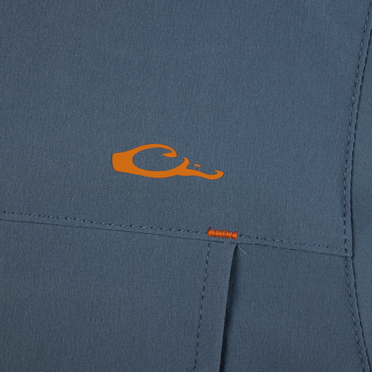 Lake Shore Performance Short Sleeve Shirt featuring an orange letter detail on blue fabric, highlighting its stretch, moisture-wicking capabilities, and vented cape back design.