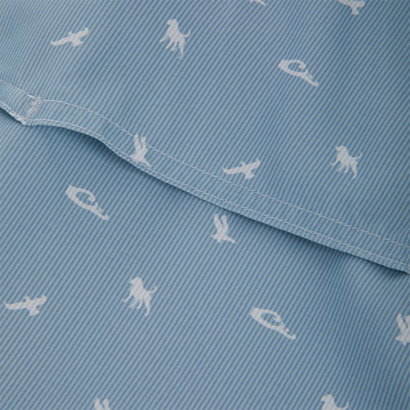 Close-up of the Cinco Ranch Western Short Sleeve Shirt showcasing light-blue striped fabric with white animal silhouettes and a visible seam, highlighting its intricate design.