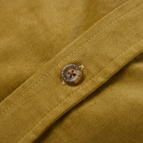 Close-up of the Drake Mid-Wale Corduroy Shirt, showcasing a horn-style button engraved with DRAKE on a stitched placket, highlighting its refined craftsmanship.