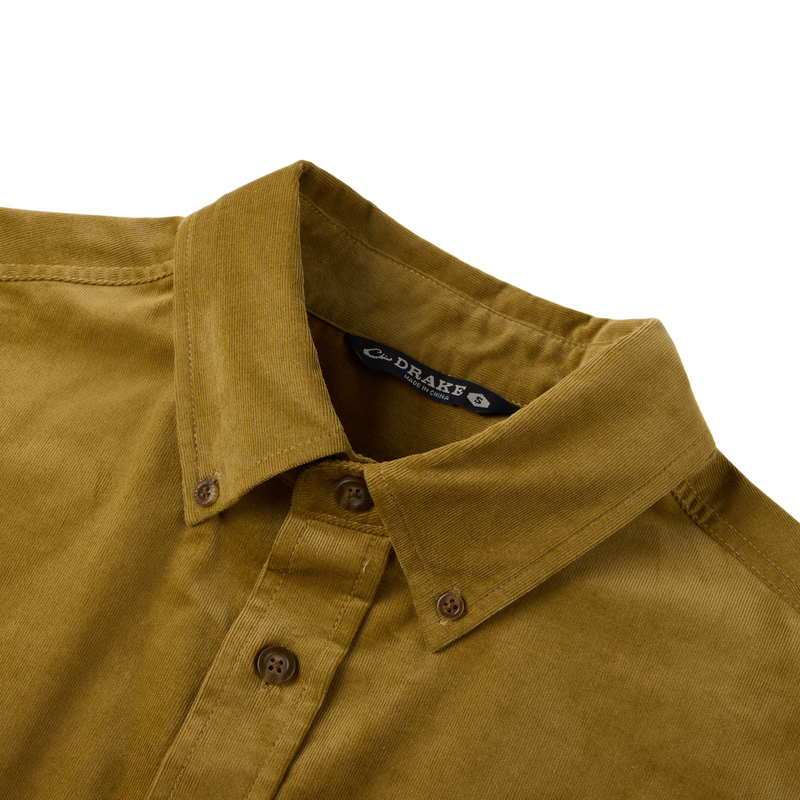 Close-up of the Midwale Corduroy Shirt collar and buttons, showcasing the mustard-yellow corduroy fabric with stretch for comfort, labeled DRAKE, size S.