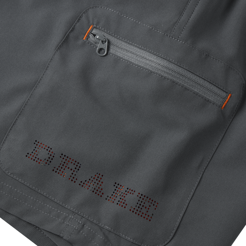 Close-up of the Lake Shore Performance Short, highlighting a zippered cargo pocket and detailed stitching, showcasing its technical design and functionality for outdoor activities.