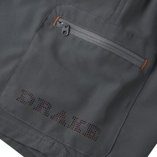Close-up of the Lake Shore Performance Short, highlighting a zippered cargo pocket and detailed stitching, showcasing its technical design and functionality for outdoor activities.
