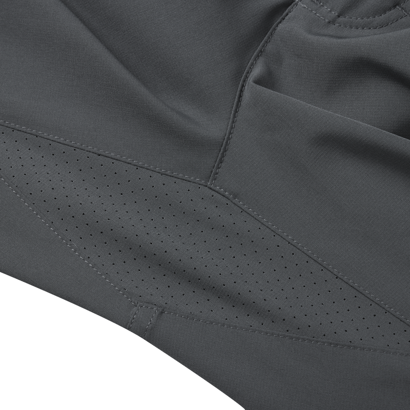 Close-up of the Lake Shore Performance Short's black fabric, showcasing its durable texture and technical design elements like laser-punched gusset and zippered cargo pocket.