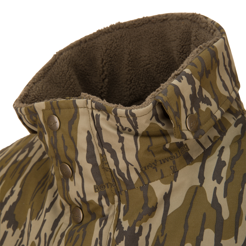 Close-up of the Throwback 80 Sport Vest collar, featuring tiger-stripe camo pattern, snap-button fasteners, and brown fleece lining for warmth and comfort.