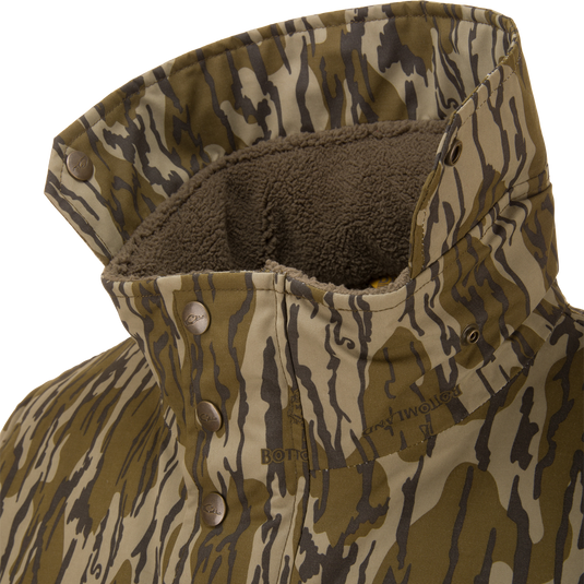 Throwback 80 Sport Vest with tiger-stripe camouflage, snap-button placket, and fleece-lined collar, designed for outdoor enthusiasts with waterproof, windproof materials and accessory pockets.