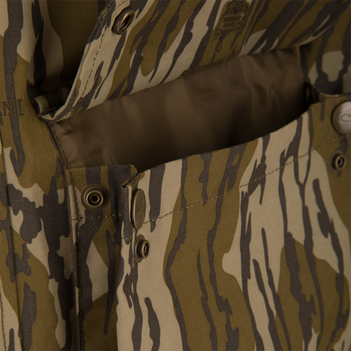 Close-up of the Throwback 80 Sport 3-in-1 Jacket featuring an open camo pocket with metal snap buttons, showcasing its durable construction and practical design for outdoor adventures.