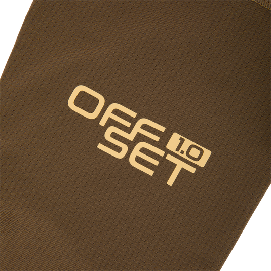 Close-up of the EST Offset 1.0 Half Zip Pullover's brown waffle-knit fabric, showcasing OFFSET 1.0 in pale yellow, highlighting its comfort and breathability features.