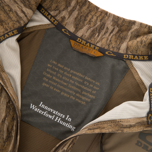 EST Offset 1.0 Half Zip Pullover interior showing Drake logo, fabric label with brand ethos, cooling technology, UPF30 protection, ergonomic thumbholes, and YKK zipper for hunting comfort.