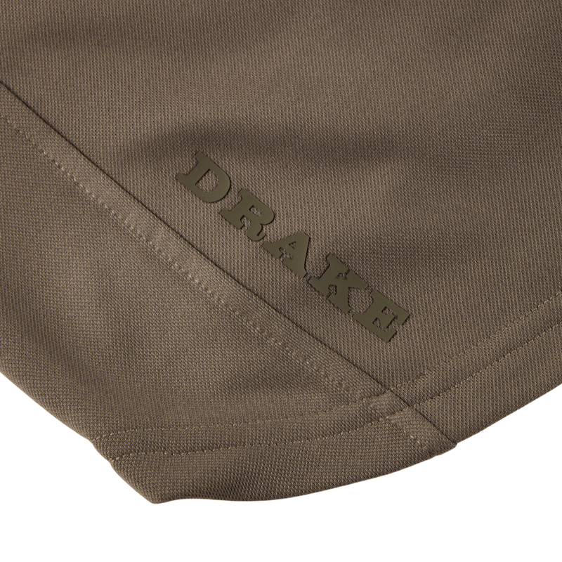 Close-up of the MST Offset 2.0 Half Zip Hoodie’s olive-drab fabric panel featuring the DRAKE brand name above a diagonal seam.