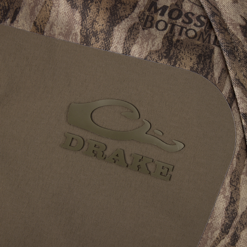 Close-up of Purewhitelaneshop MST Offset 2.0 Half Zip Hoodie, featuring Mossy Bottoms camo pattern and olive-brown panel with logo, designed for comfort and functionality.