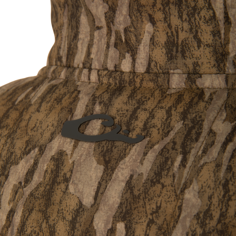 Close-up of LST BMF Jacket with Primaloft, showing camo-patterned fabric, a black Q emblem, and detailed stitching, highlighting its durable, water-resistant ripstop material.