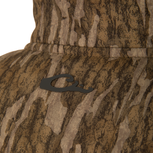 Close-up of LST BMF Jacket with Primaloft, showing camo-patterned fabric, a black Q emblem, and detailed stitching, highlighting its durable, water-resistant ripstop material.