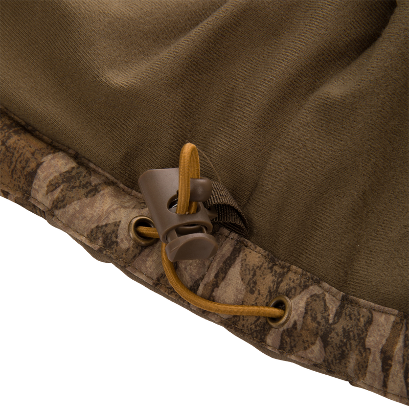 Close-up of LST BMF Vest hem, featuring an olive-brown and camo design with a tan drawcord and toggle, showcasing durable, water-resistant construction.