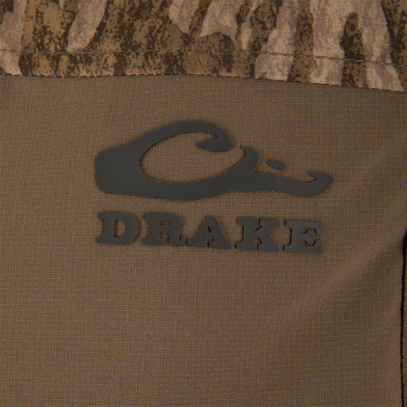 Close-up of the LST BMF Vest with Primaloft, featuring the Purewhitelaneshop logo on camouflage fabric, showcasing its windproof, water-resistant materials, and practical Magnattach™ pocket.