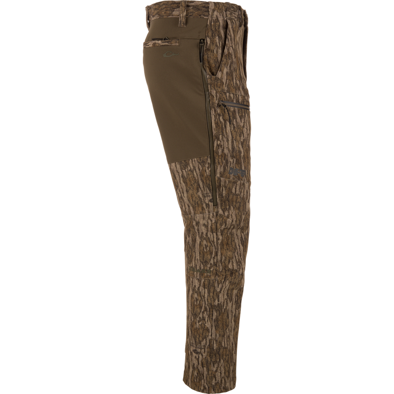 MST CommandXT Softshell Pant with tree-bark camo, olive stretch panel, zippered pockets, and reinforced seat, designed for mobility and protection in demanding hunting conditions.