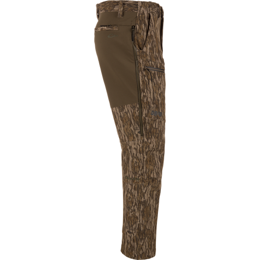 MST CommandXT Softshell Pant with tree-bark camo, olive stretch panel, zippered pockets, and reinforced seat, designed for mobility and protection in demanding hunting conditions.
