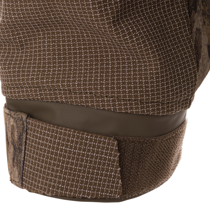 Close-up of LST CommandXT 3-in-1 PrimaLoft Insulated Jacket's check-patterned textile strap with Velcro closure, highlighting its rugged construction for all-weather adaptability.