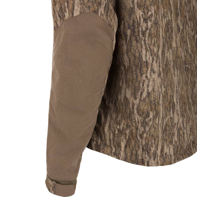 Camouflage CommandXT 3-in-1 PrimaLoft Insulated Jacket on mannequin, highlighting grid-textured elbow panel, Velcro cuff, exemplifying rugged, versatile hunting gear.