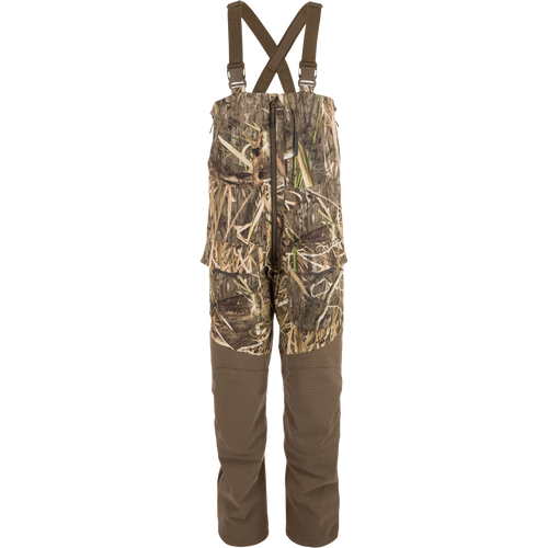 LST CommandXT Bib with Primaloft: Camouflage bib-overalls featuring adjustable suspenders, reinforced panels, waterproof zippers, cargo pockets, and articulated knees, designed for extreme hunting conditions.