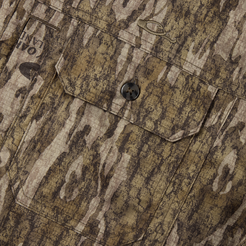 The EST Wingshooter Trey Long Sleeve Shirt features a vented back, multiple pockets, and a hidden button-down collar, ideal for outdoor enthusiasts.