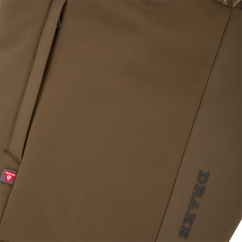 LST BMF Eqwader Full Zip with Primaloft showing zippered pocket with PrimaLoft tag and DRAKE branding, highlighting its technical features for outdoor adventures.