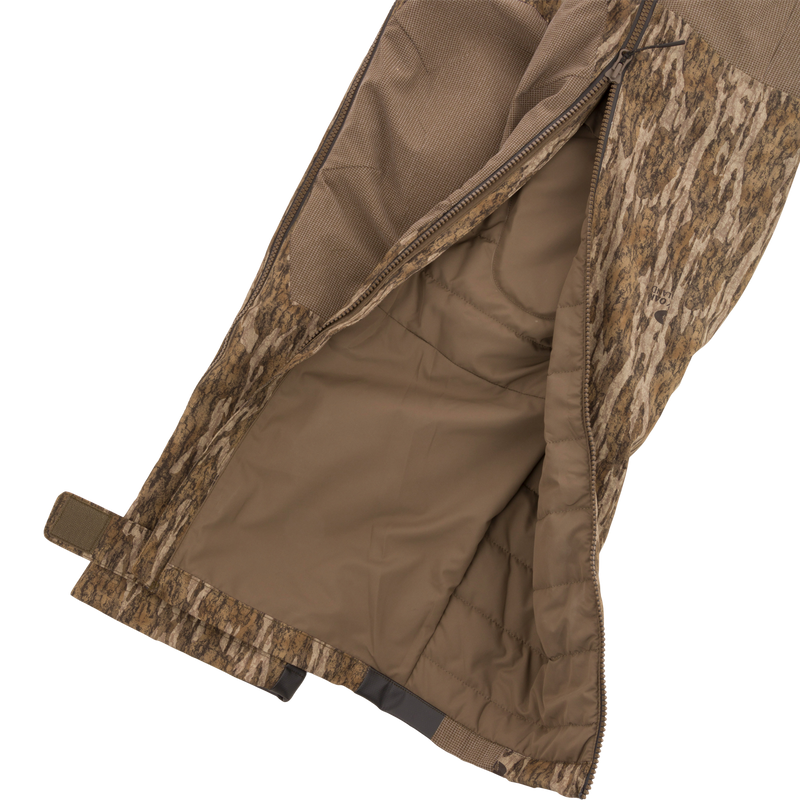 LST BMF Pit Bib with Primaloft, showcasing camo outer shell, quilted lining, long zipper, Velcro ankle strap, and boot hooks for rugged hunting conditions.