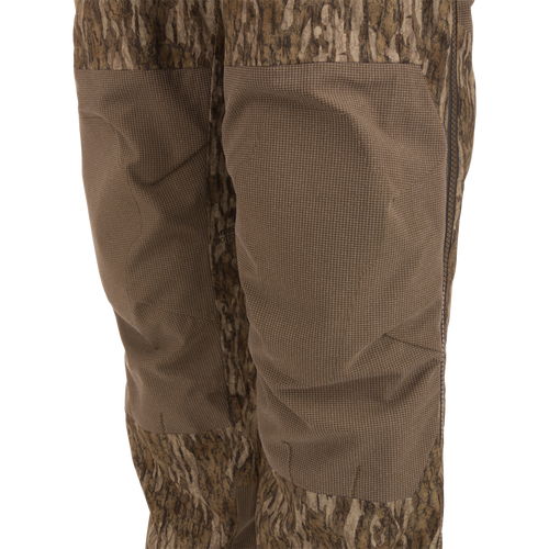 Close-up of LST BMF Pit Bib highlighting camo design, reinforced knee panels, and side zipper, showcasing durable construction and weather protection for rugged hunting conditions.