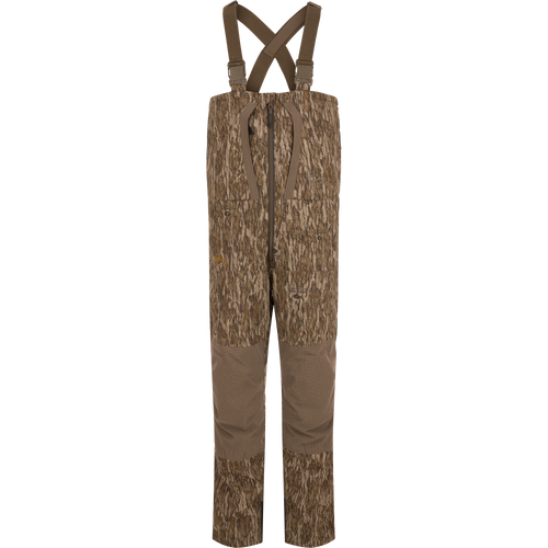 LST BMF Pit Bib with Primaloft: Camo-patterned hunting bib pants with reinforced brown fabric, adjustable suspenders, central front zipper, knee pads, and side zips for rugged performance.