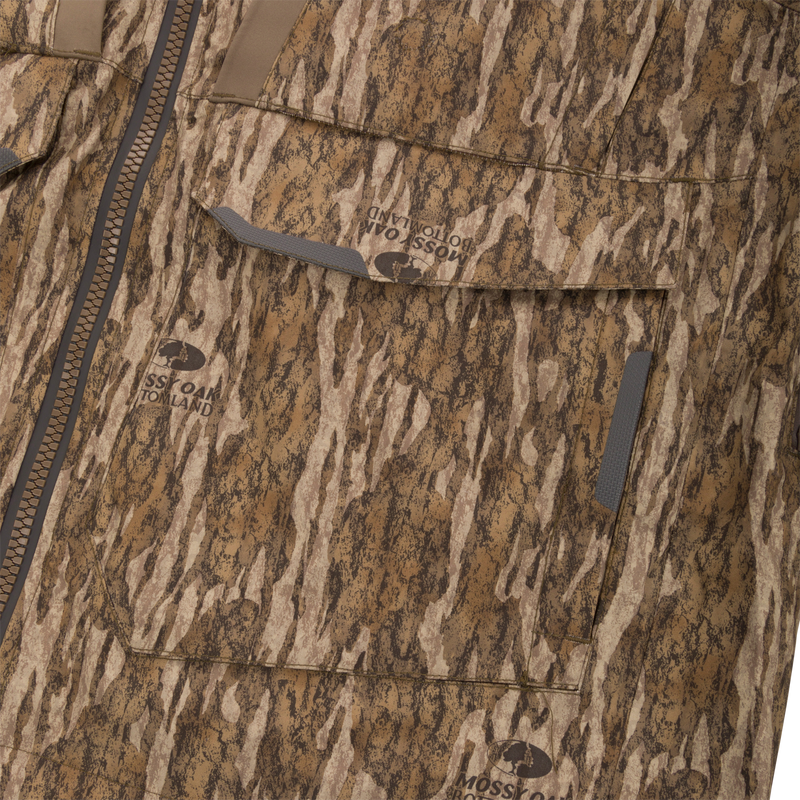 Close-up of the LST BMF Pit Jacket showcasing its Mossy Oak Bottomland camouflage pattern, front zipper, and Velcro-flap pockets, designed for extreme hunting conditions.