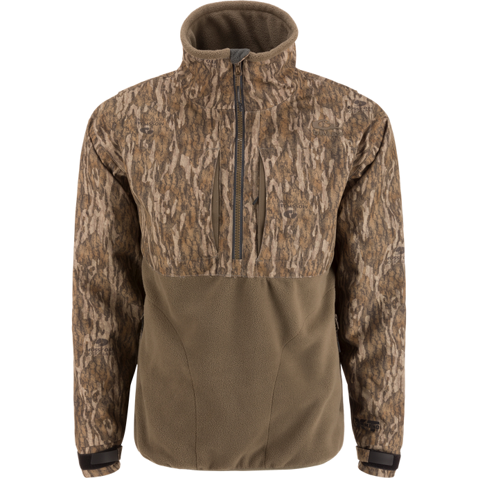 MST CommandXT Eqwader Half Zip Jacket with camo-patterned upper, olive fleece lower, zippered chest pockets, storm flap, and adjustable cuffs, ideal for rugged outdoor use.