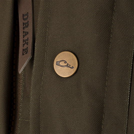 Close-up of the Throwback 80 Featherless Puffer Jacket, featuring a brass snap button, leather zipper pull with DRAKE, and rugged stitching, ideal for outdoor wear.
