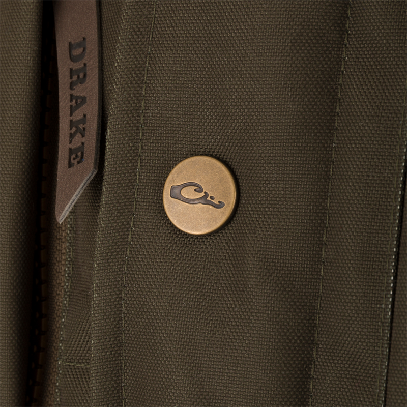 Close-up of the Throwback 80 Featherless Puffer Vest, highlighting its waterproof polyester material, fleece collar, and durable brass snaps.