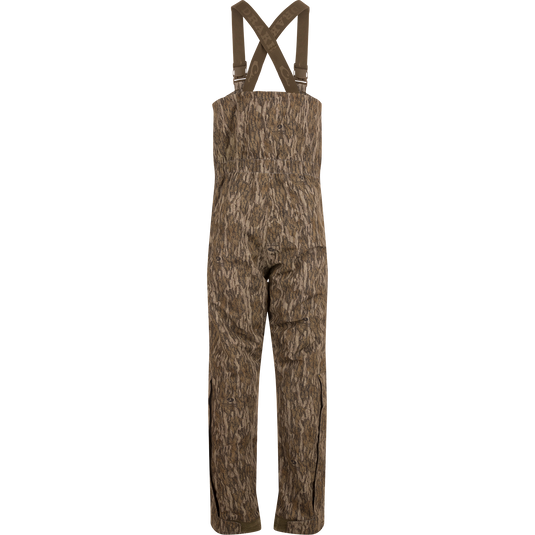 LST Hardline Insulated Bib, camouflage-patterned, features adjustable suspenders, waterproof polyester, synthetic down insulation, YKK zippers, and articulated knees, ideal for harsh outdoor conditions.