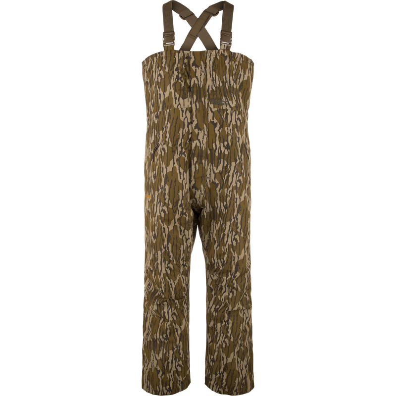 LST Hardline Insulated Bib: Camouflage-pattern, waterproof chest-high waders with adjustable straps, handwarmer pockets, and articulated knees for enhanced mobility in harsh hunting or fishing conditions.
