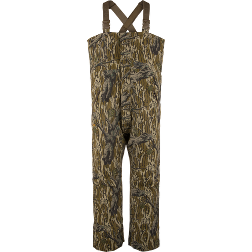 LST Hardline Insulated Bib featuring a tree-bark camouflage pattern, adjustable shoulder straps, and articulated knees for mobility, designed for warmth in harsh hunting conditions.