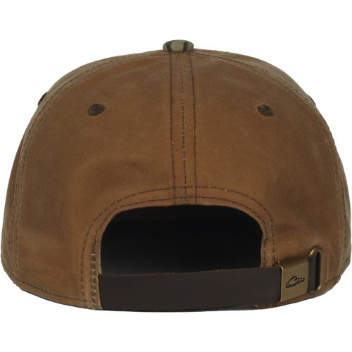 Back view of the Waxed Flatbill Ball Cap showcasing its adjustable leather strap, metal buckle, and two ventilation eyelets on the unstructured, mid-crown design.