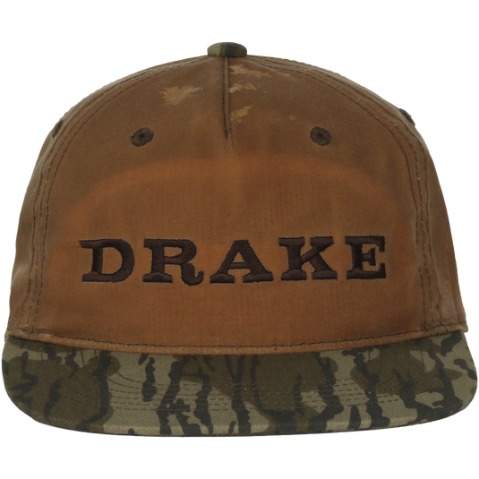 Waxed Flatbill Ball Cap with a worn brown canvas crown and camouflage brim, featuring DRAKE embroidery, offering a stylish and comfortable fit.