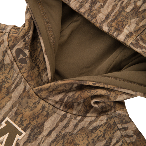 Youth Performance Hoodie in camouflage with an olive-lined hood, showcasing a stitched M on the chest and a kangaroo pocket, designed for young athletes' comfort and versatility.