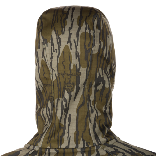 Grid Fleece Half Zip Hoodie in Bottomland Mossy Oak camo, showing back, hood, and faint logo. Features include moisture-wicking grid-fleece, stretch fabric, and water-resistant pocket.