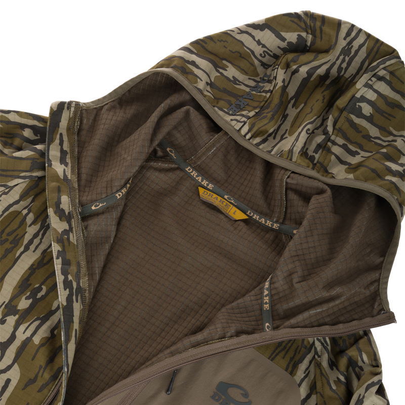 Grid Fleece Half Zip Hoodie with tiger stripe camo, partially unzipped to show grid-fleece lining, taped seams, and a zippered chest pocket with DRAKE logo.