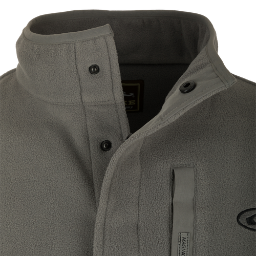 A close-up of the Camp Fleece Pullover 2.0, a lightweight poly-fleece jacket with a neck snap closure and vertical Magnattach™ chest pocket. Perfect for layering in Spring or Fall.