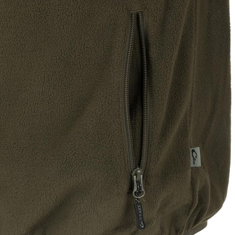 Camp Fleece Vest: Close-up of a zipper on a jacket, featuring a black and silver zipper pull. Perfect for layering under Drake outerwear.