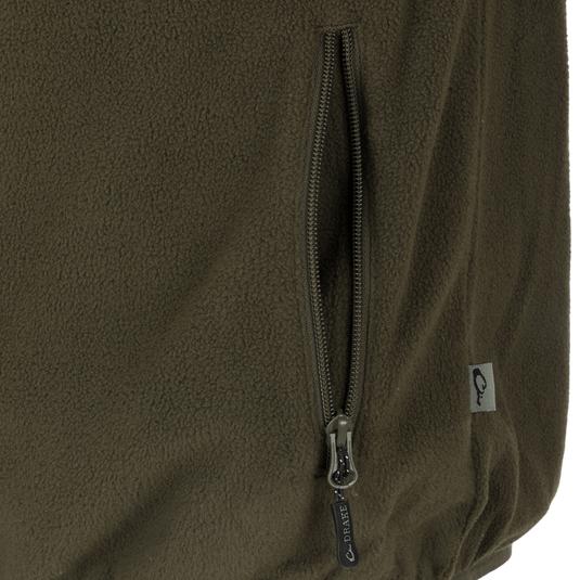 Camp Fleece Vest: Close-up of a zipper on a jacket, featuring a black and silver zipper pull. Perfect for layering under Drake outerwear.