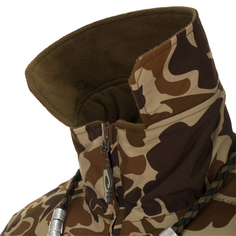 MST Waterproof Fleece-Lined Quarter Zip Jacket close-up showing camouflage pattern, high fleece-lined collar, partially unzipped zipper, braided drawcord, and metal cord locks.